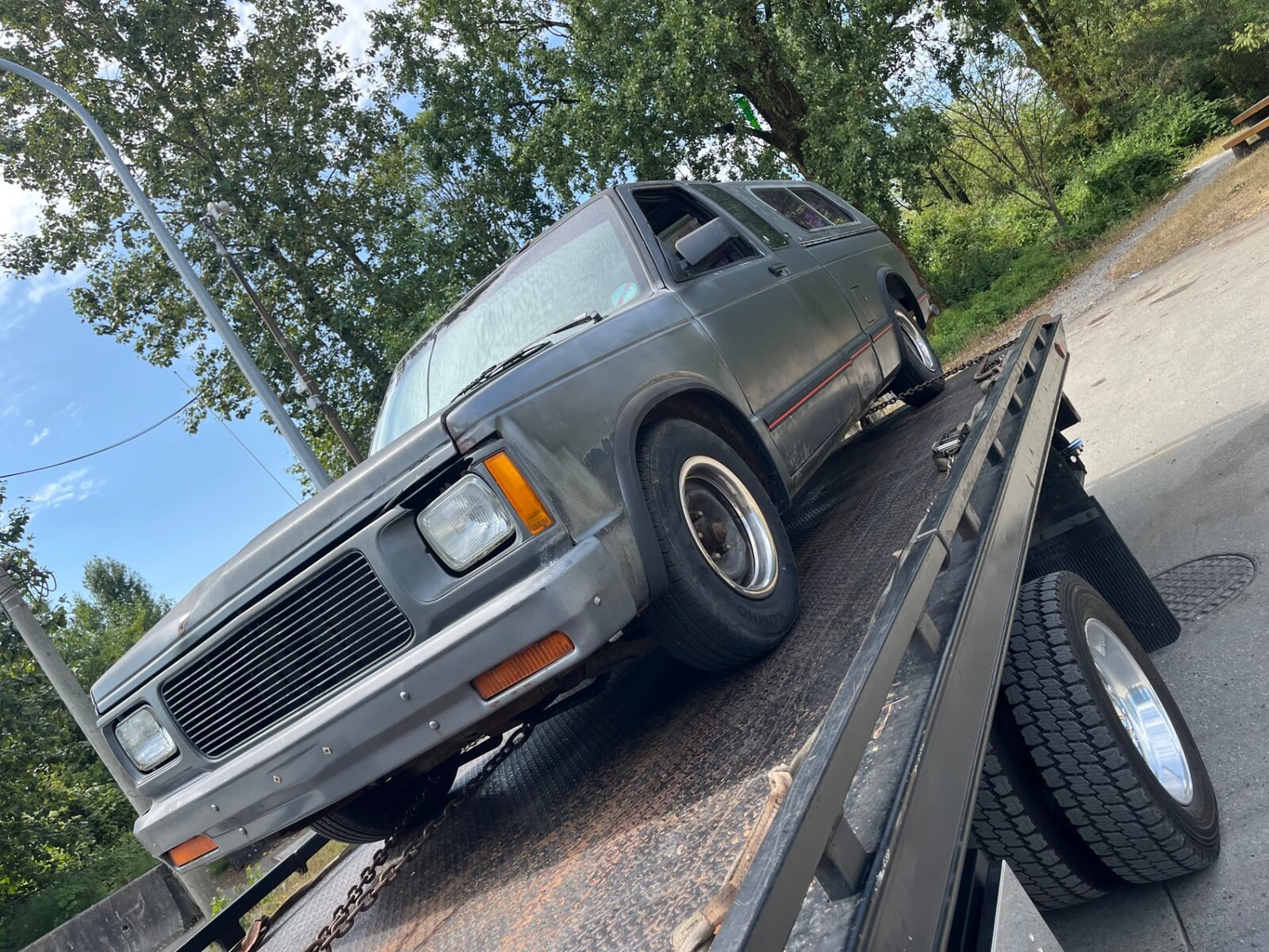 Grey GMC Safari van loaded on Jay's flat deck tow truck in Mission, BC